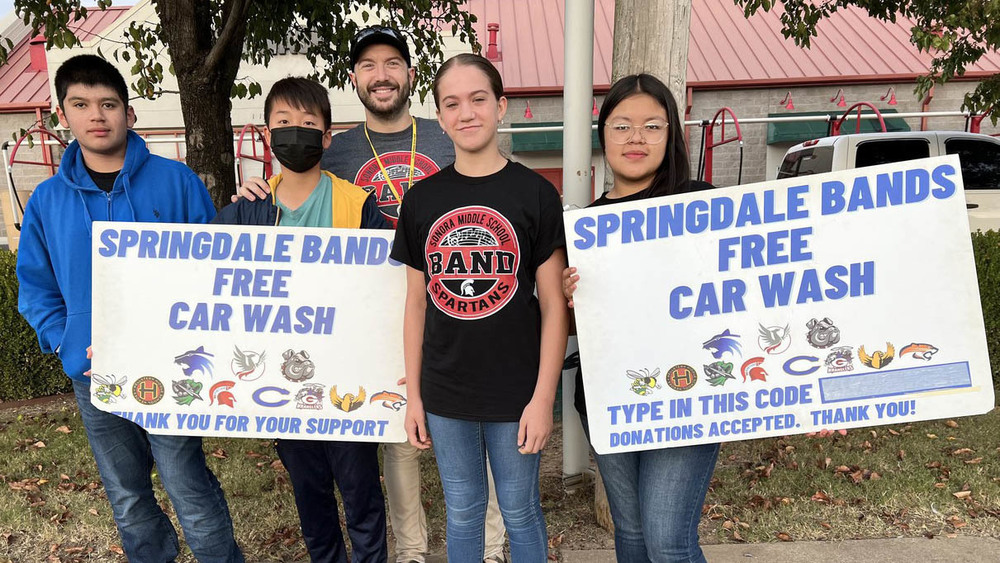 Students holding a free car wash sign