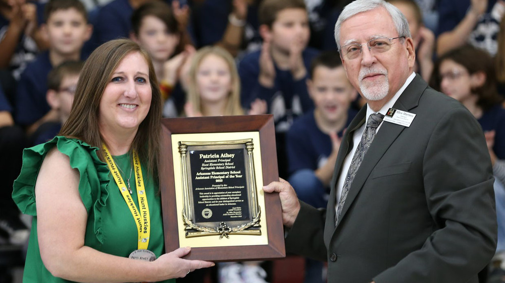 Mike Mertens. AAESP assistant executive director, recognizes Patricia Athey, Hunt Elementary School assistant principal, with the 2022 Assistant Principal of the Year award on Dec. 5. 2022, at a surprise assembly at Hunt Elementary School.